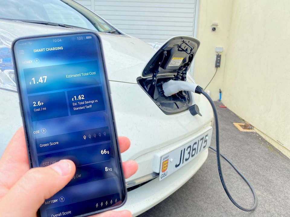 Person monitors electric car charging on smartphone
