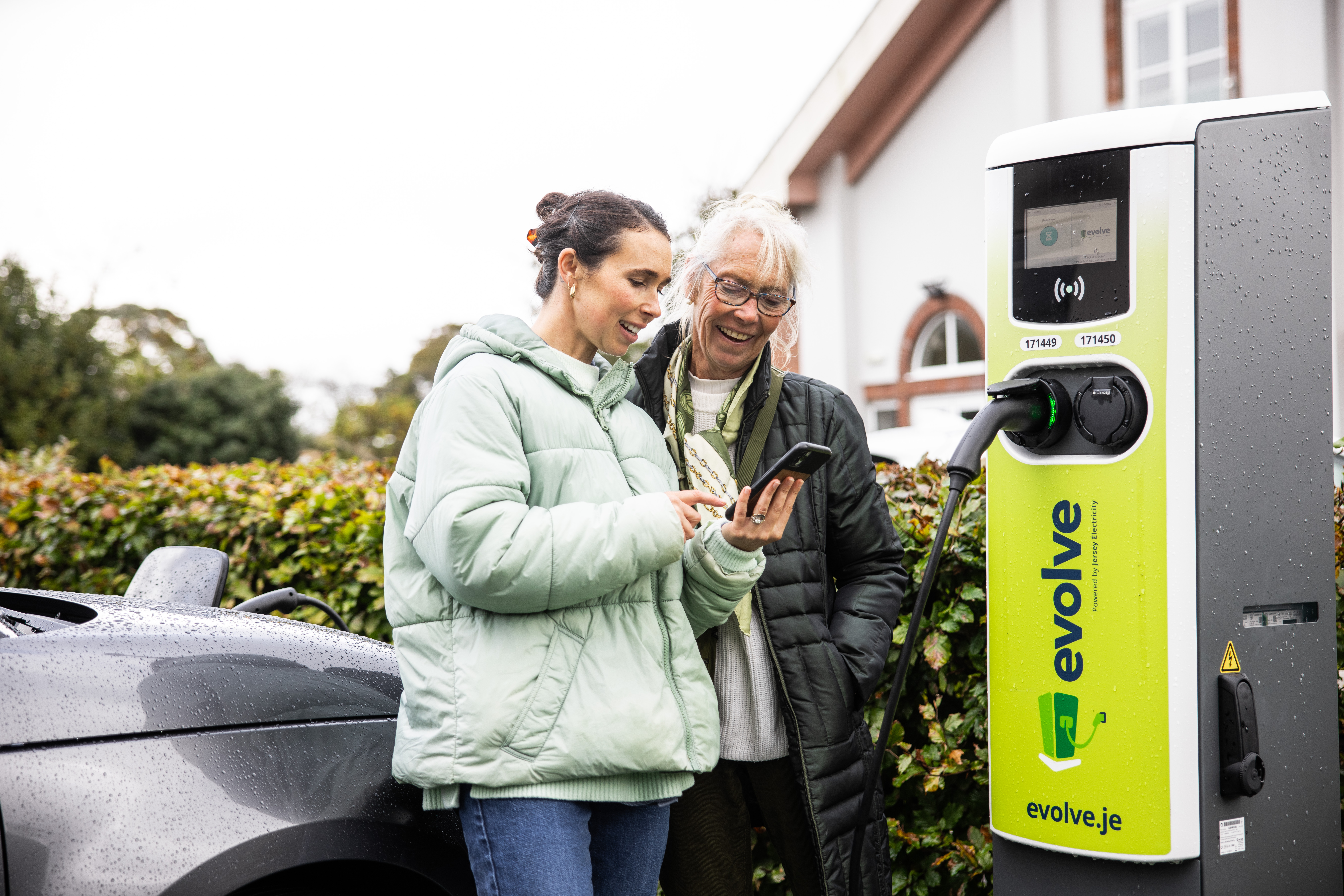 Evolve charge point with two ladies standing by to start their charge
