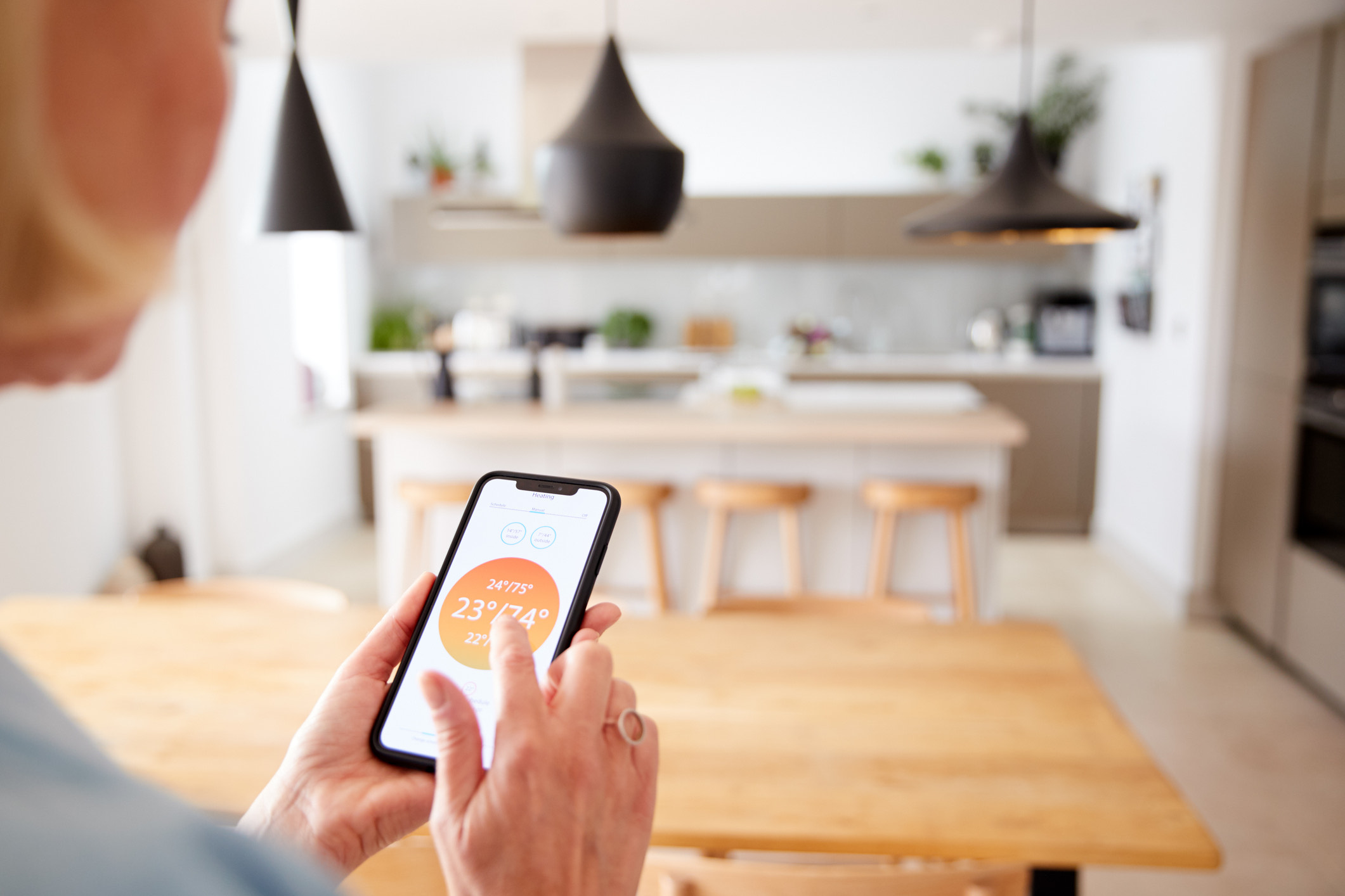 Woman using phone to control her heating