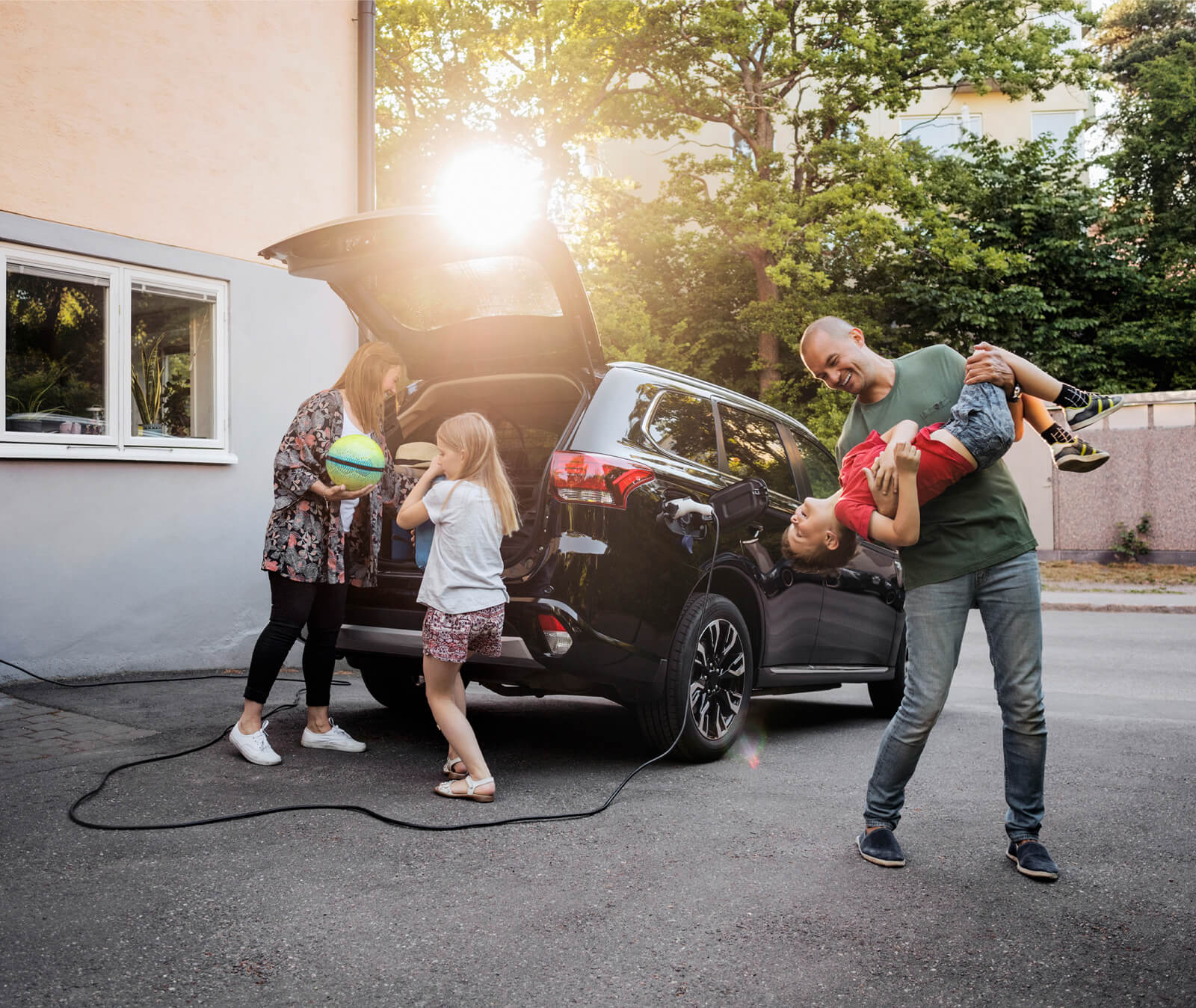 Family of four unpacking an electric car