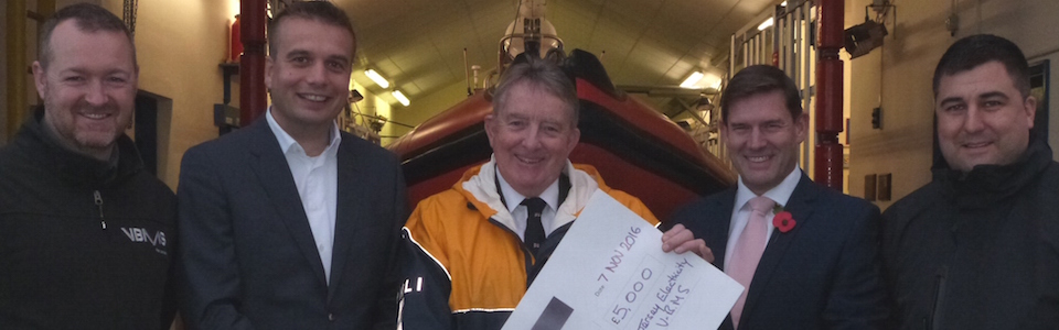 JE & RNLI team members with cheque
