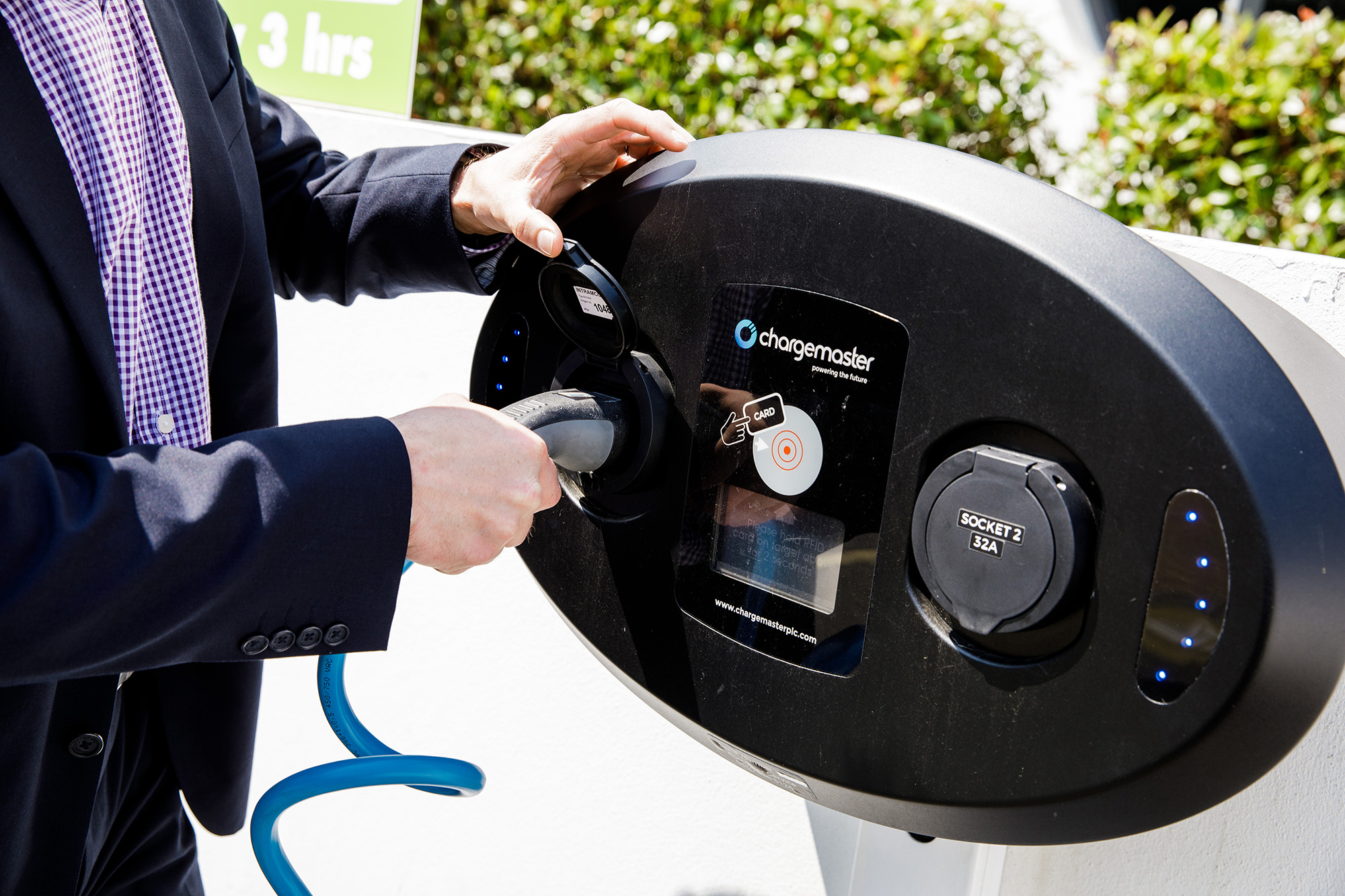 A man in a suit uses the electric vehicle charger at The Powerhouse