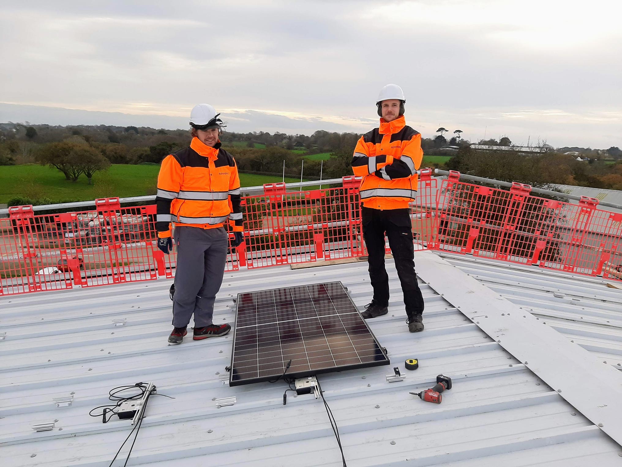 Two members of the Sunworks team begin the Solar PV installation on the roof at Jersey Dairy.