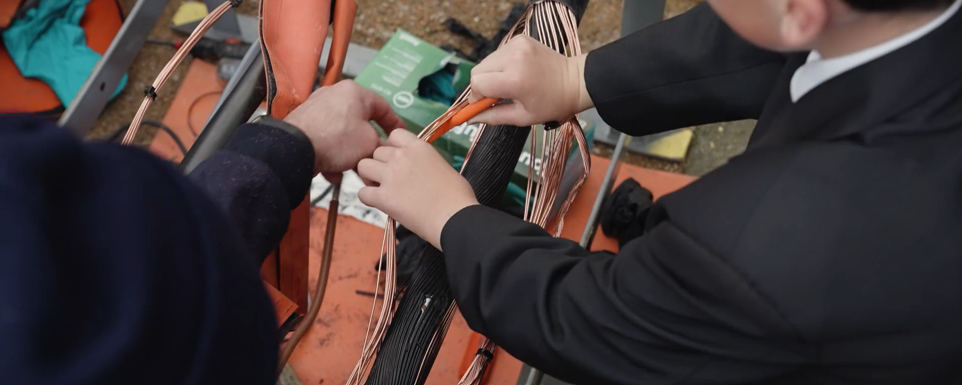 A close up shot of a student being shown how to work on electrical demostration equipment