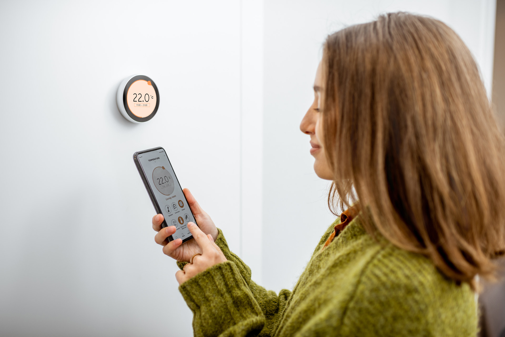 Woman programming heating with smart phone