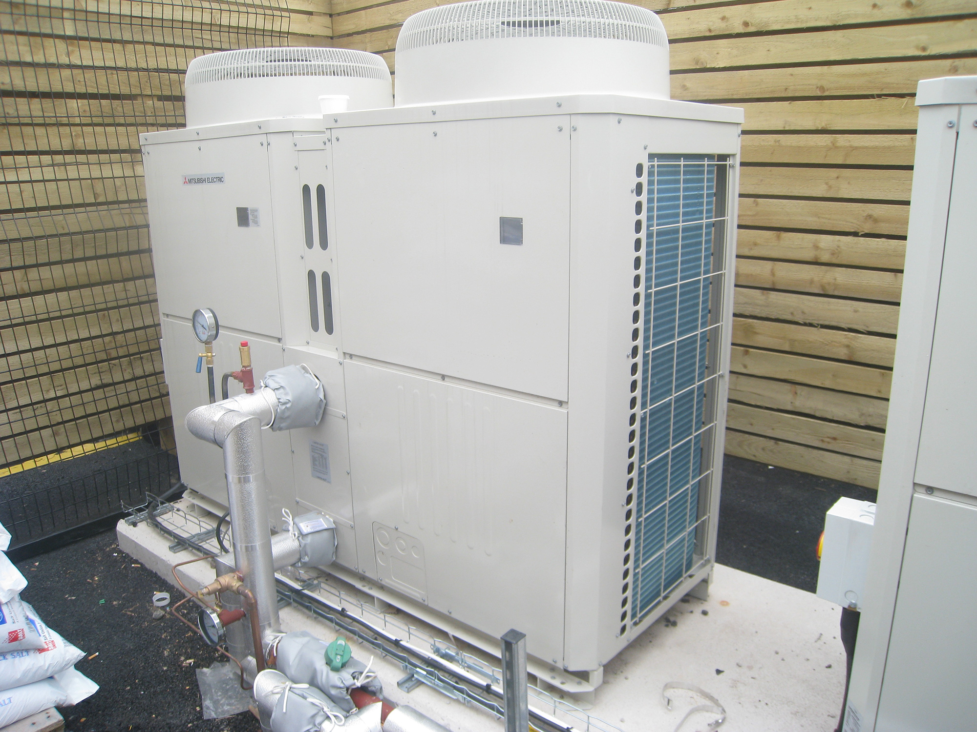 A commercial heat pump system installed in a custom built area.