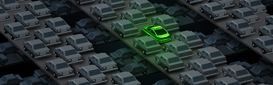 One green car amongst many grey cars