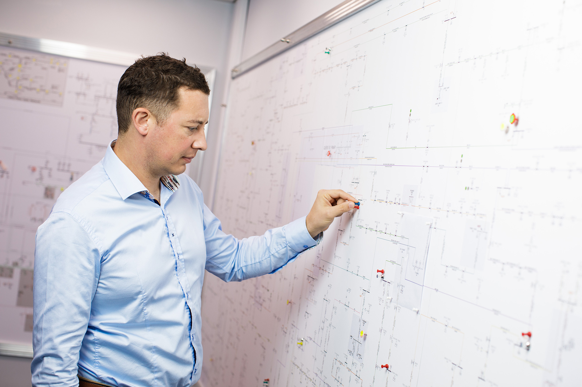 Ashley Mariner, a Jersey Electricity Engineer inspects a wall of drawings.