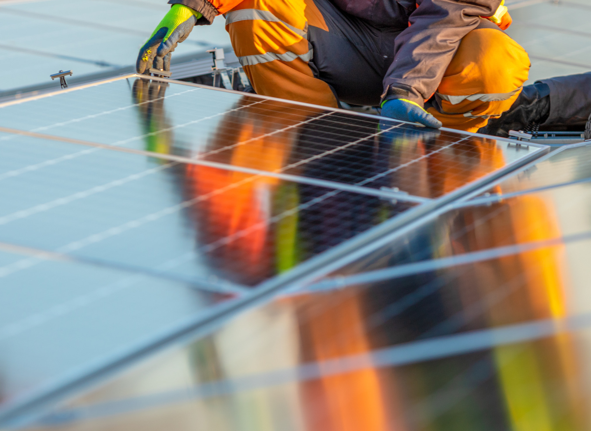 Man installing solar panels on roof