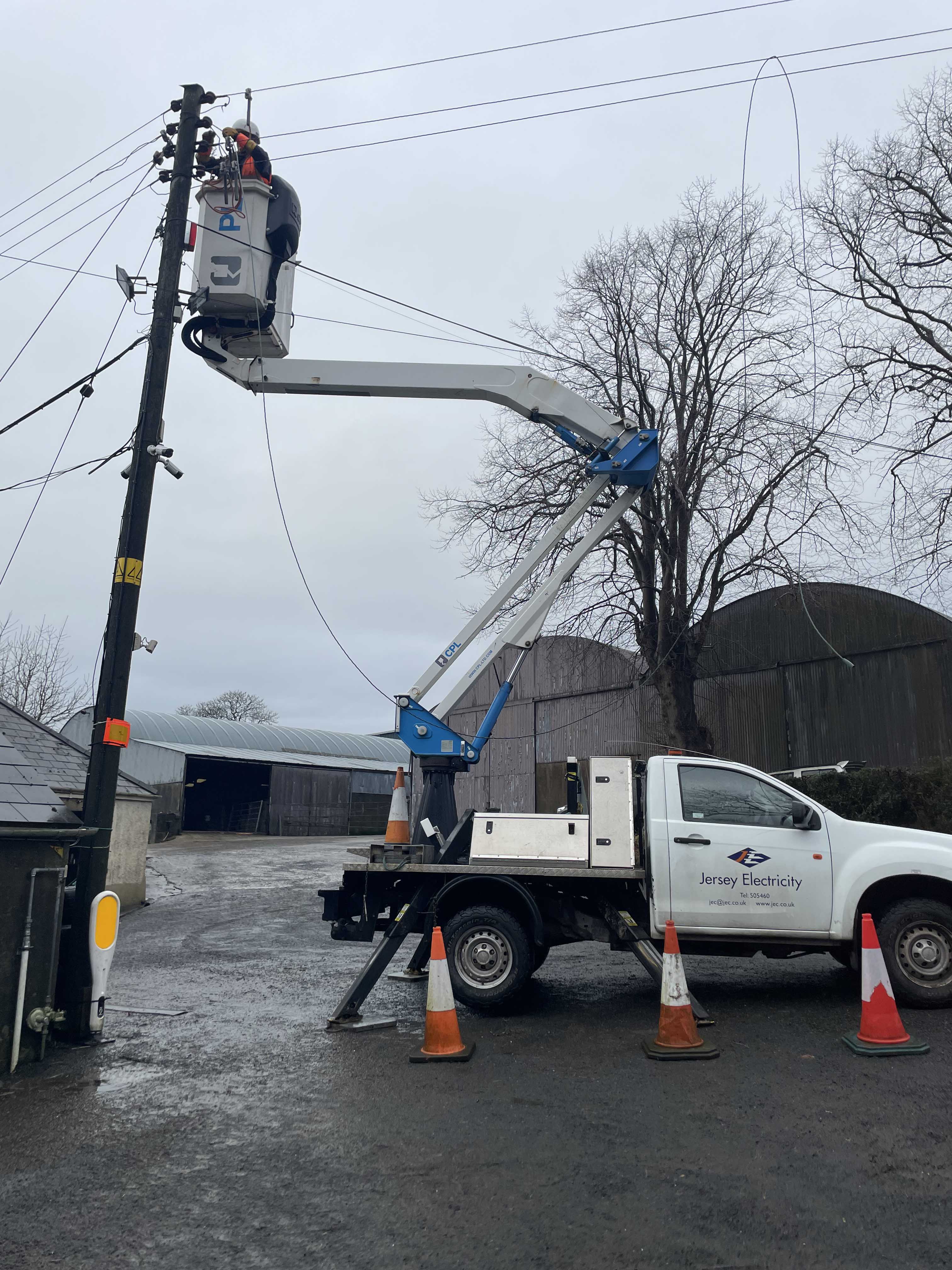 A JE linesman in PPE fixing an overhead line in storm Éowyn, Norther Ireland