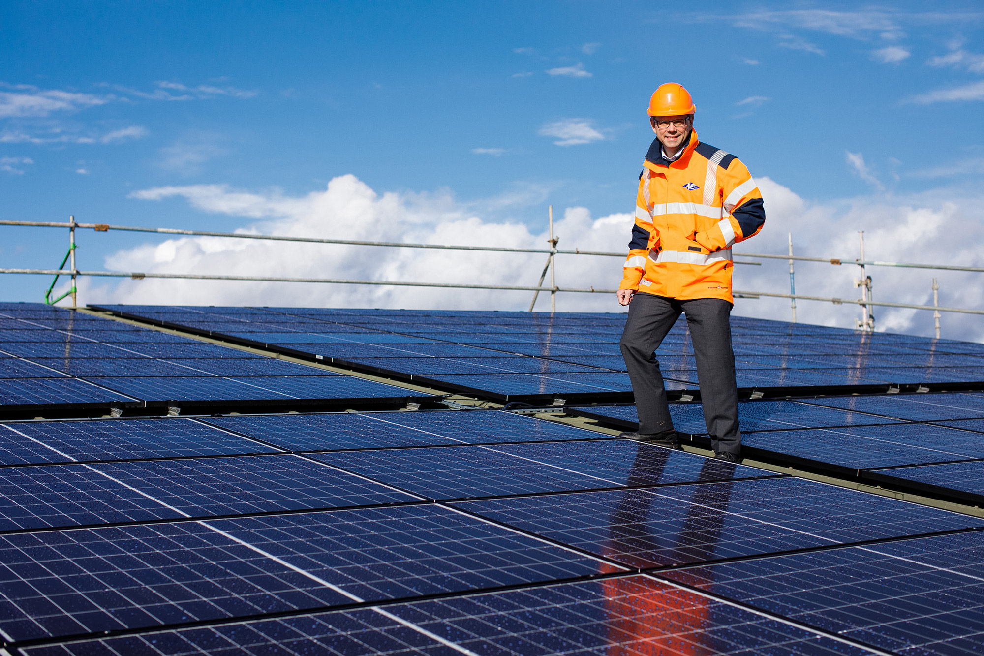 Chris Ambler, Jersey Electricity's Chairman, stands on top of the solar array installed on the roof of the powerhouse.