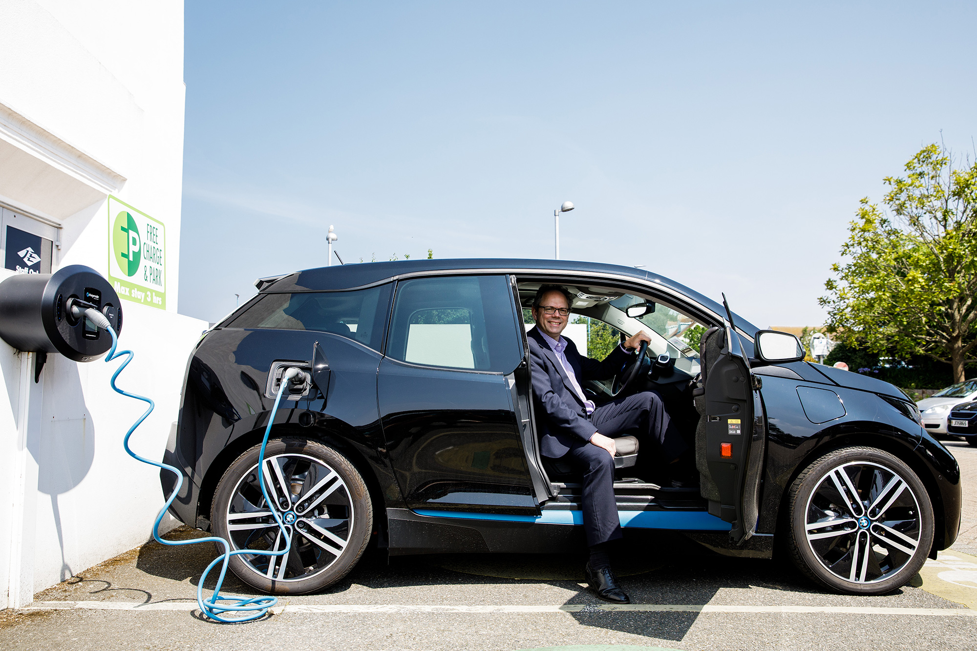 Chris Ambler sits in an electric vehicle whilst it charges at The Powerhouse.